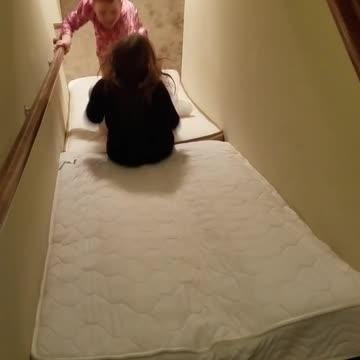 Cute Puppy Dominates Stairway Mattress Slide Sending Kids Into Hysterics
