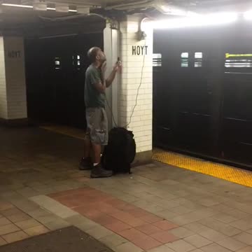 Man shaves on subway station
