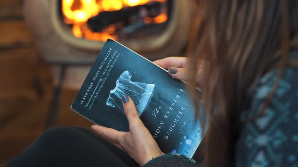 a woman reading a book while camping in the forest