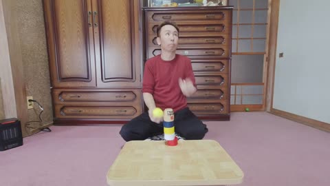 Guy Knocking Away a Daruma Doll Piece While Juggling