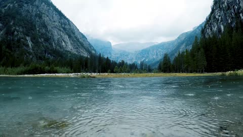 A serene and calming experience is watching the gentle rainfall on a river.