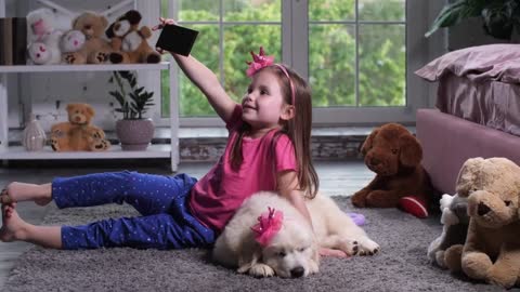 Cute elementary age child posing for selfie shot holding smartphone sitting