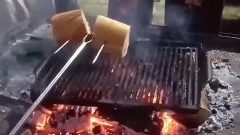 Flaming salmon with bread on the campfire