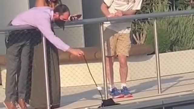 Things get a little sketchy when woman tries to retrieve her hat over the railing of a building.