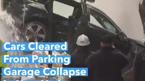 Crews clear vehicles from the site of a multi-story parking garage