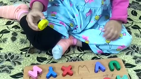 Two and half years intelligent girl playing A to Z on the table