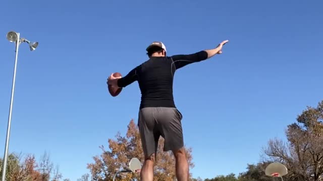 Guy Tosses Football Into Basketball Hoop While Balancing Himself Over Slackline