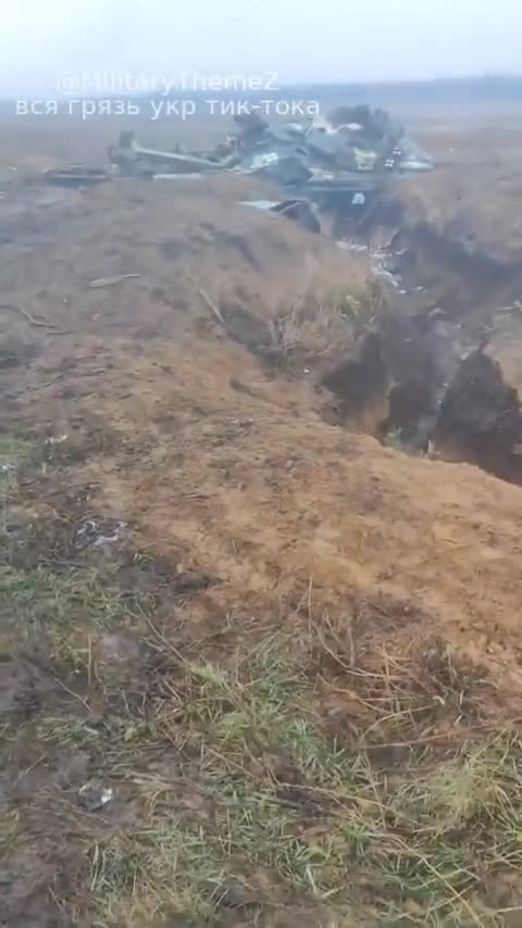 Ukrainian soldiers record a destroyed Ukrainian T-64A with mining cleaning equipment