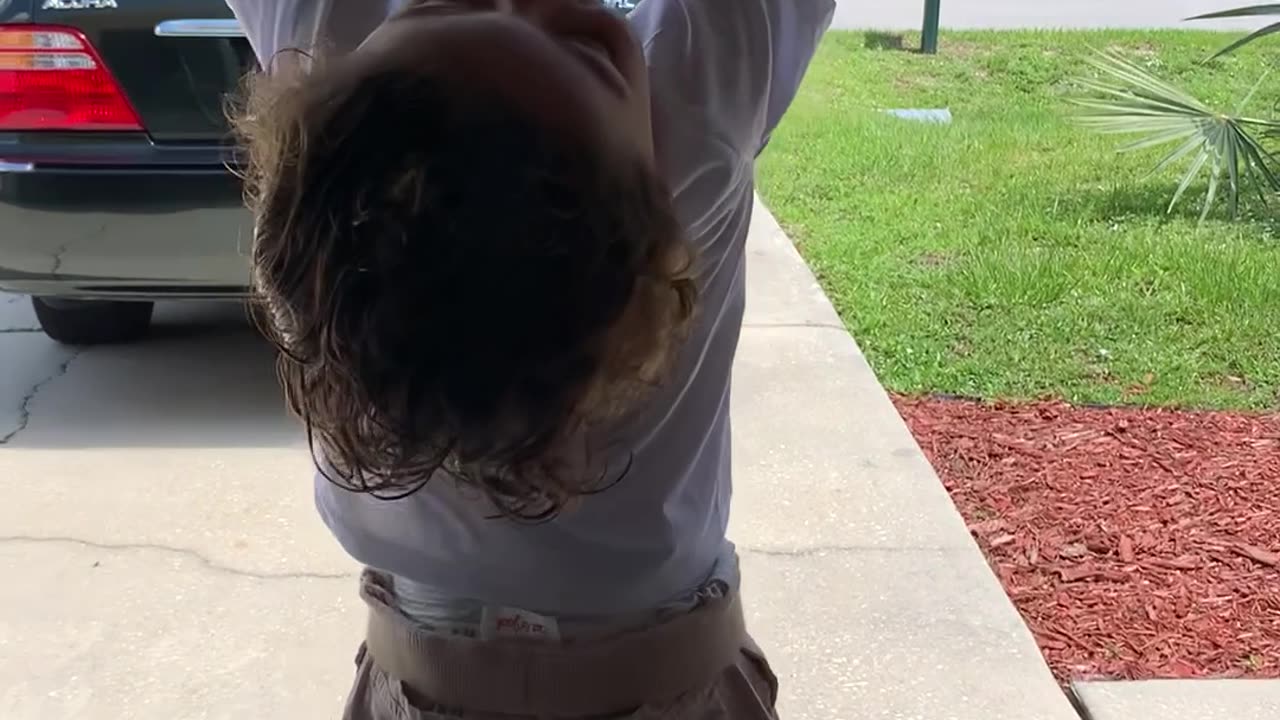 Little Boy Hangs on to Opening Garage Door