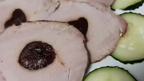Sliced stuffed pork garnished with cucumber