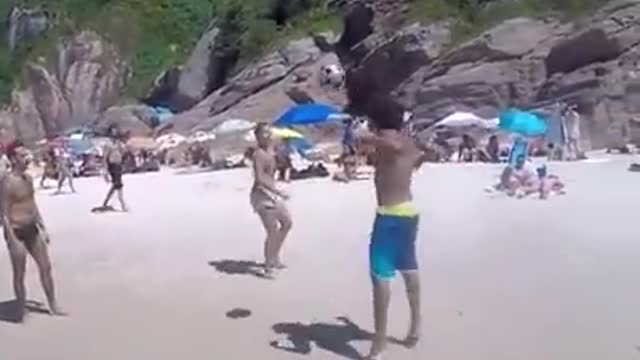 Dog playing football in the beach