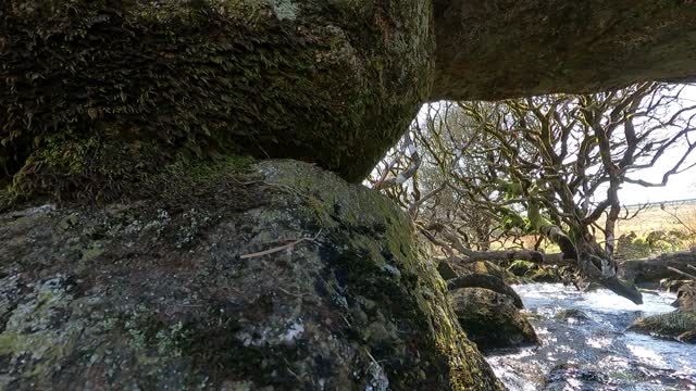 Under a granite bridge ove a river.