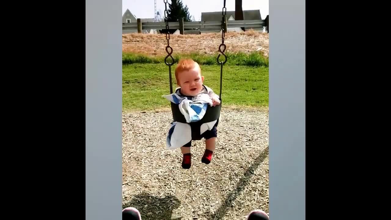 The baby plays on the swing