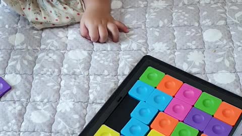 A 2-year-old Korean baby doing puzzles.