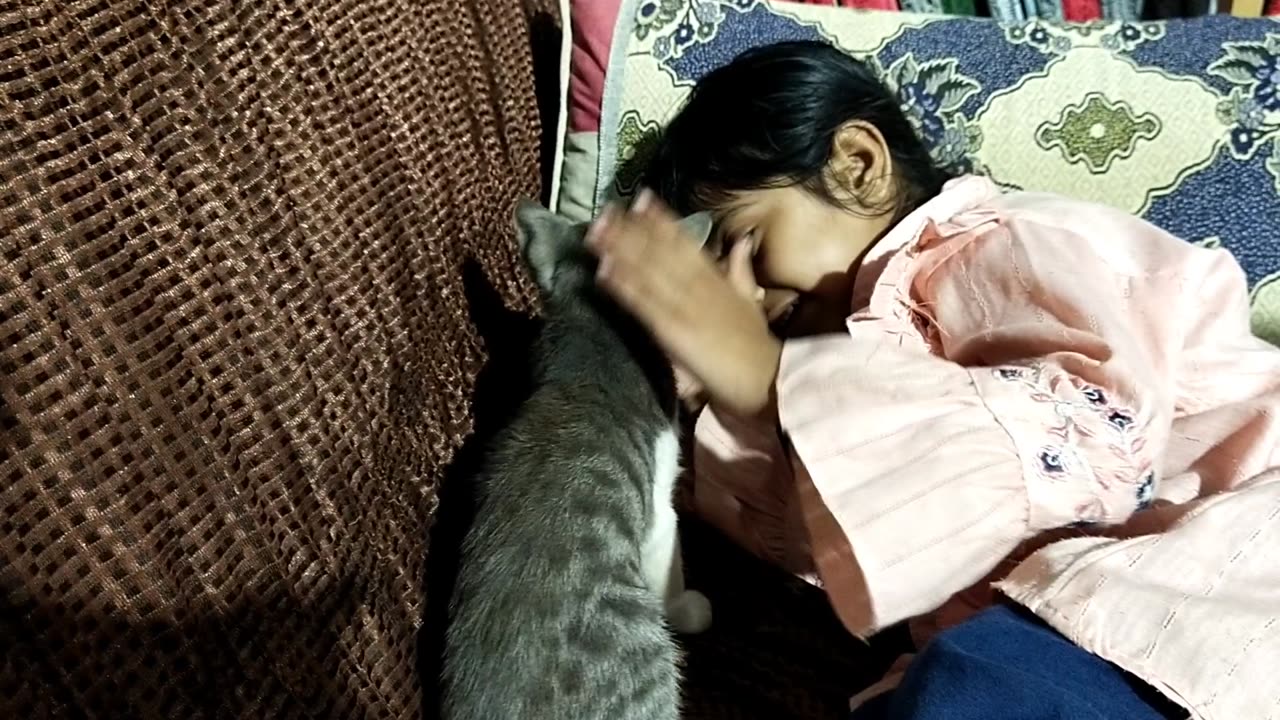 A Muslim girl playing with a cat in islamic center