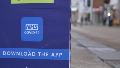 Handheld Close Up Shot of COVID NHS Application Signage In City Centre