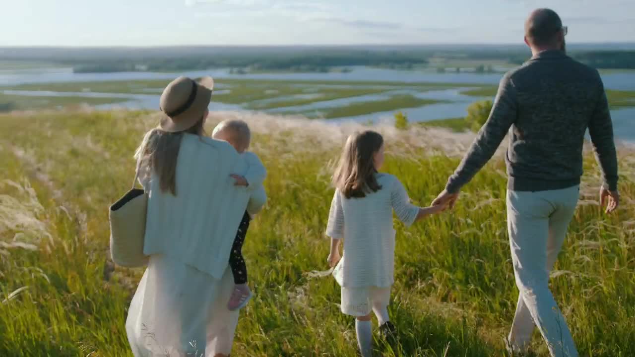 Young family walking down the hill to the river