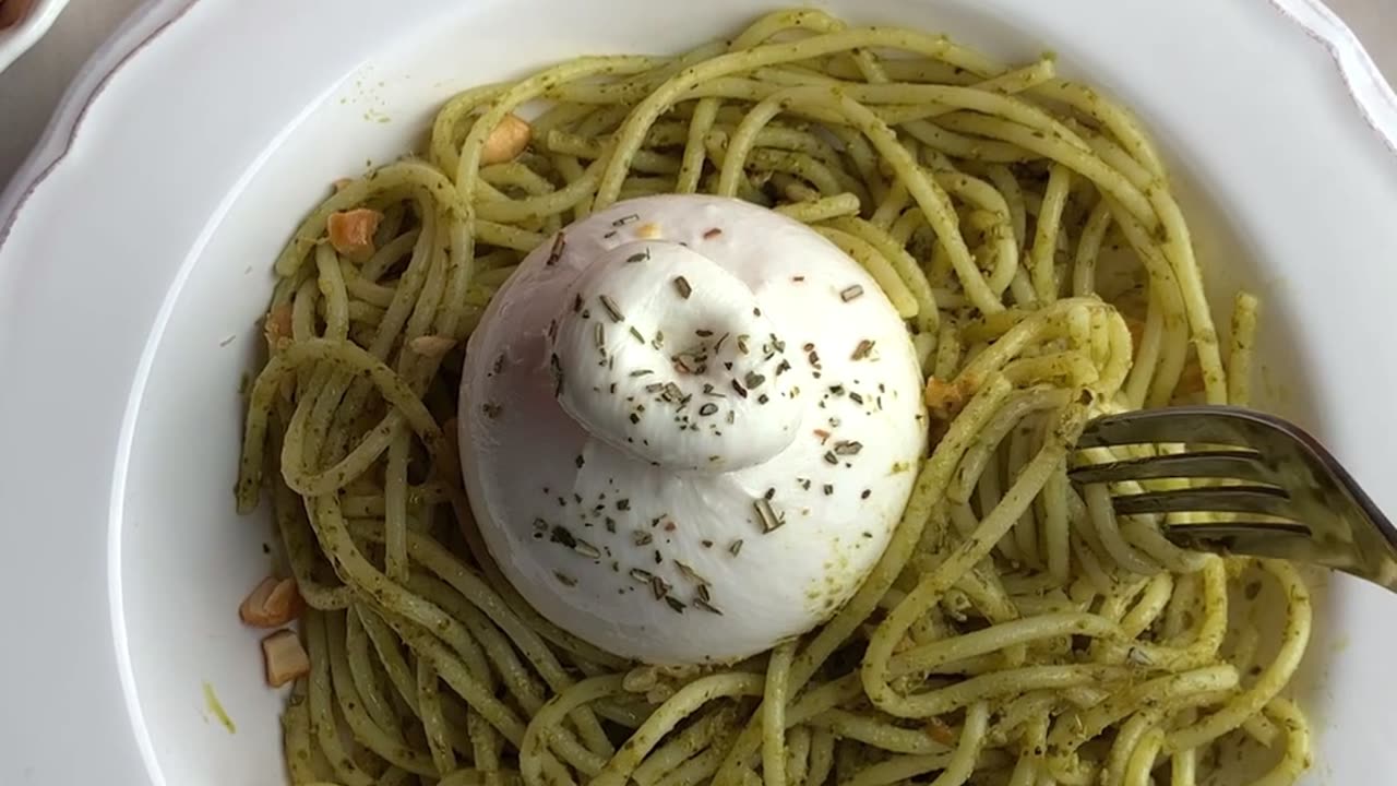 Eating delicious spaghetti with pesto with mozzarella on top