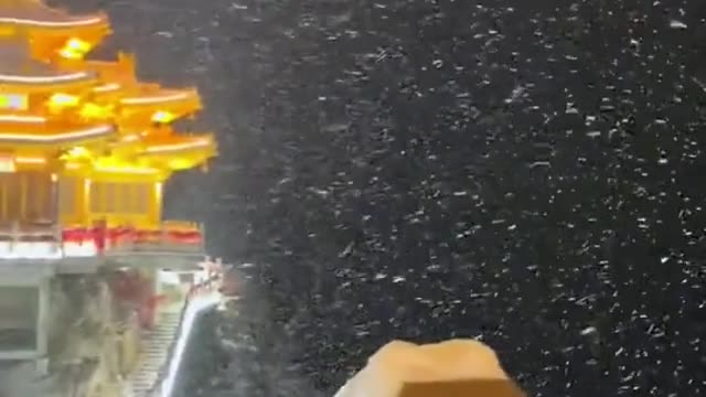 An entry view of a Chinese temple in the mountains during a storm