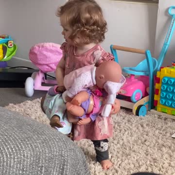 Little girl dances with her baby dolls