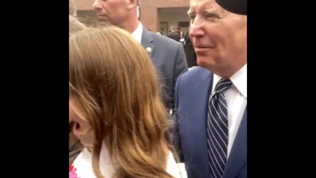 President Joe Biden grabs a young girl by the shoulder