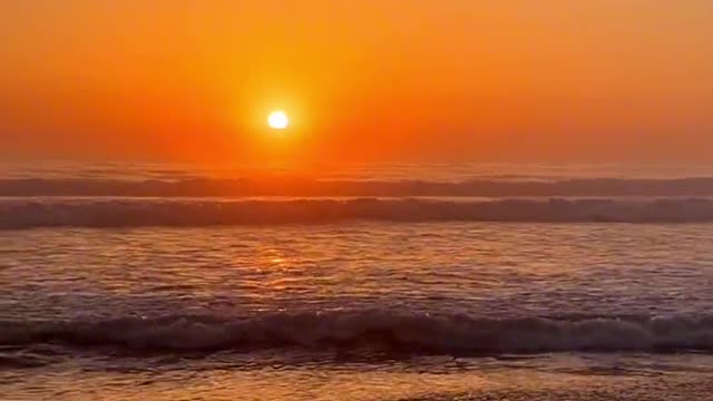 Walking on the beach at dusk, waiting for a sunset and a rising moon