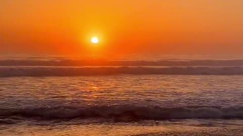 Walking on the beach at dusk, waiting for a sunset and a rising moon