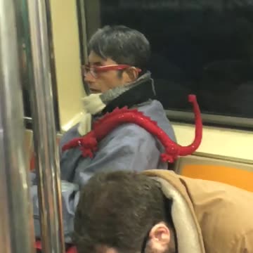 Glasses guy on subway has red dragon on his shoulder