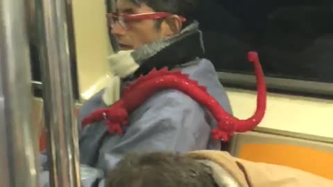 Glasses guy on subway has red dragon on his shoulder