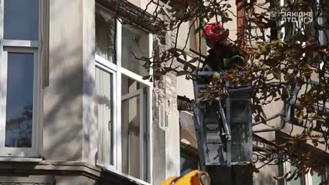 Guardsmen help victims at the site of a Russian rocket impact in Lviv