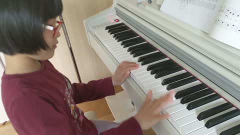 The girl who plays a happy birthday song by the piano.