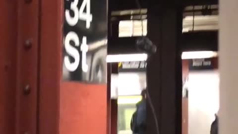 Man red jacket charging phone in subway