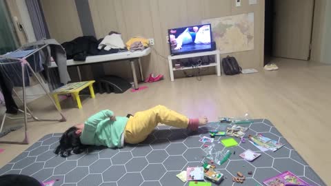 a child exercising while watching tv