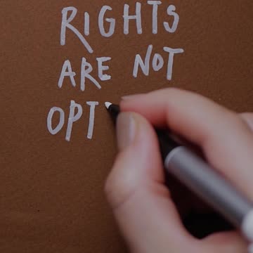 A Person Writing a Phrase on Brown Paper