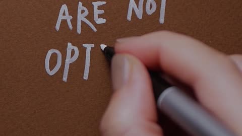 A Person Writing a Phrase on Brown Paper