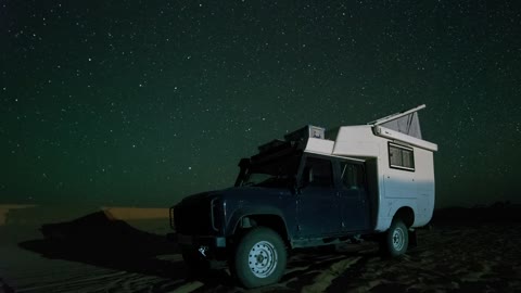 Camper van in the Sahara desert at night
