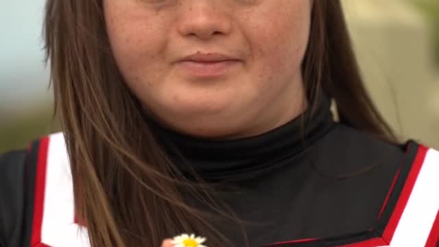 a-girl-holding-a-small-flower