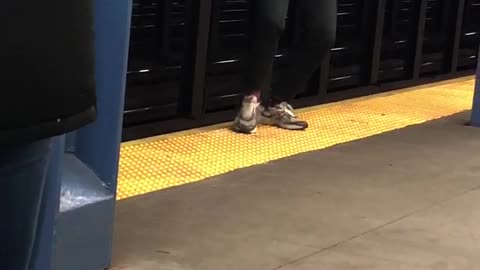 Man dances at the edge of subway station platform to guitar song