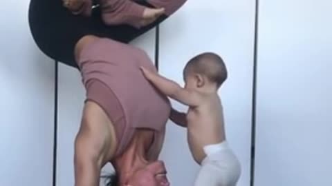 Child Climbs On Mom Performing Yoga Pose