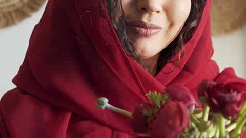 a-woman-holding-a-vase-of-rose-flowers