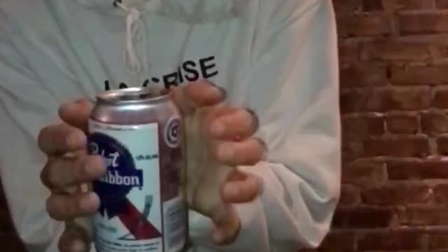 Guy in white la crise sweater does floating tricks with white beer can