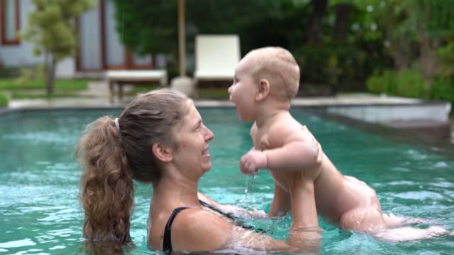 Mother and child taking a bath in the swimming pool.