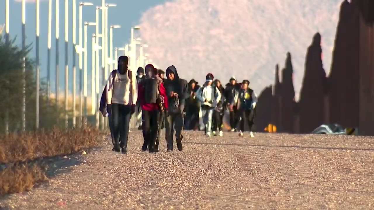 Masses of illegal aliens pour into the U.S. through a border wall breach cut by smugglers.