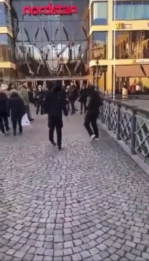 Christian preacher draped in Swedish flag is attacked and kicked by two masked migrant youths.