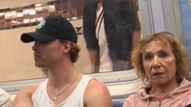 Guy white shirt dancing in front of subway window reflection