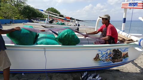 Fishermen are cleaning fish in fishing nets