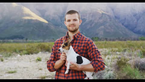 Caucasian man looking at camera with his dog in his arms