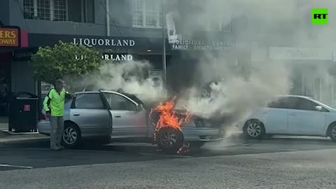 AUSTRALIAN MAN WHO LIVES IN A SIMULATION INSIDE HIS PINEAL GLAND CASUALLY LOADS UP FLAMING CAR WITH BEER