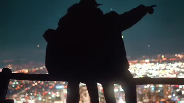 The couple sat on the railing at the top of the hill