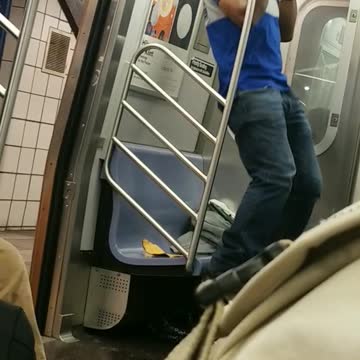 Guy black hat blue shirt doing pull ups subway